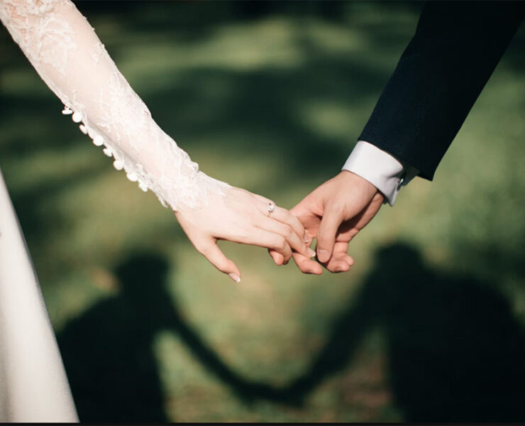 Just married wedding couple, romantically holding hands