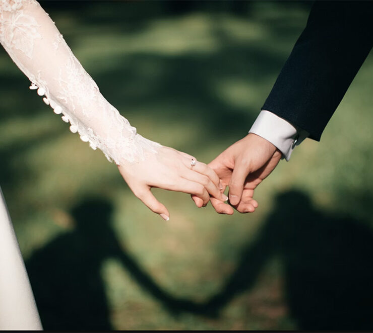 Just married wedding couple, romantically holding hands