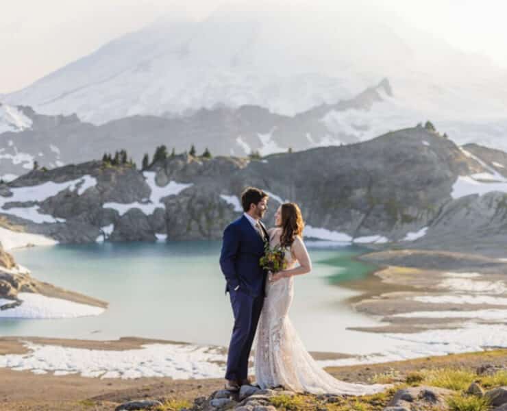 Just married, a couple embraces in a mountain setting