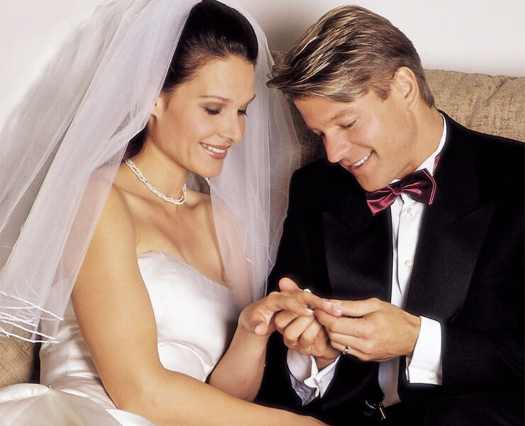Groom looks at the bride's ring on their wedding day