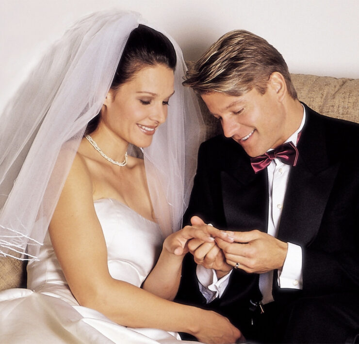 Groom looks at the bride's ring on their wedding day