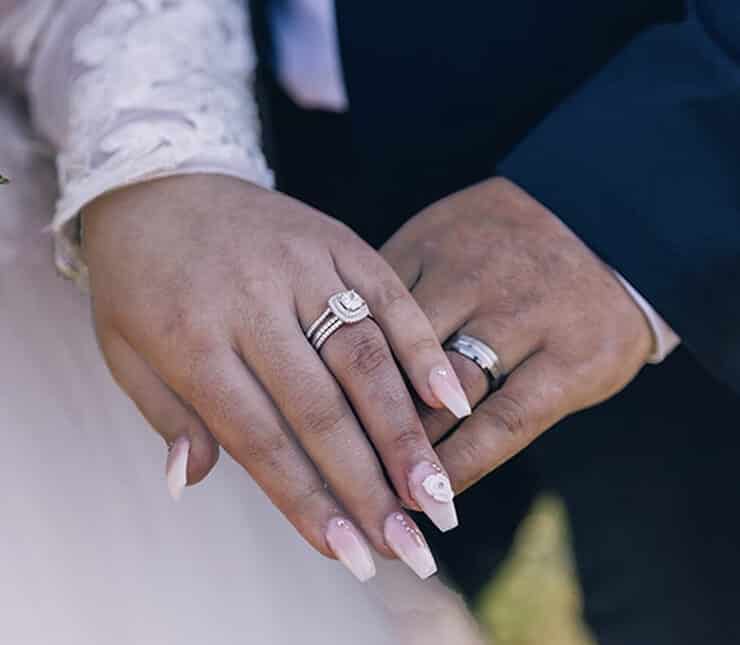 Newlyweds holding hands and siplaying their new weddings rings