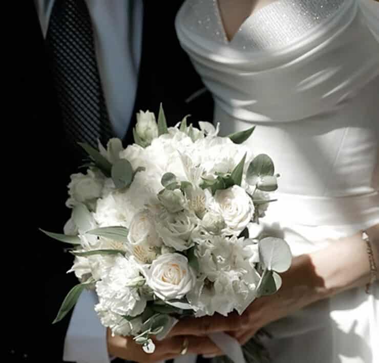 Bride and Groom hold ivory bouquet